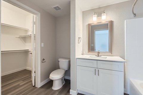 A white toilet sits in a small bathroom next to a sink.