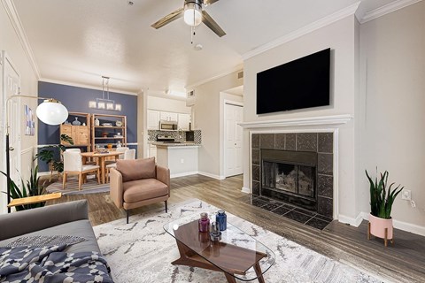 A living room with a grey couch and a fireplace.