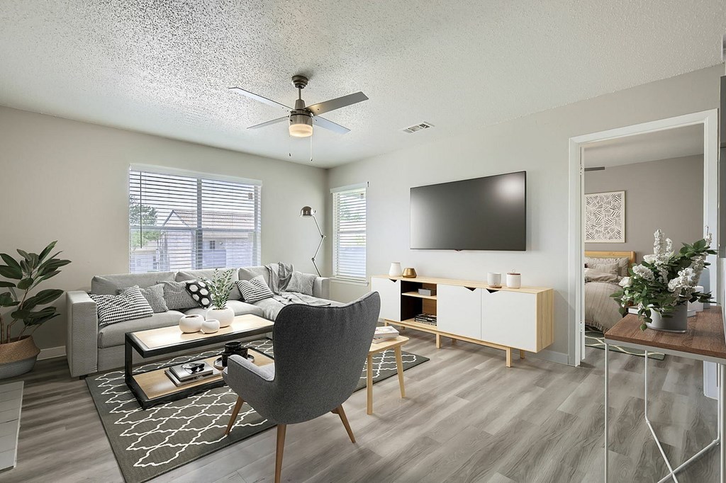 A living room with a grey chair and a grey couch.