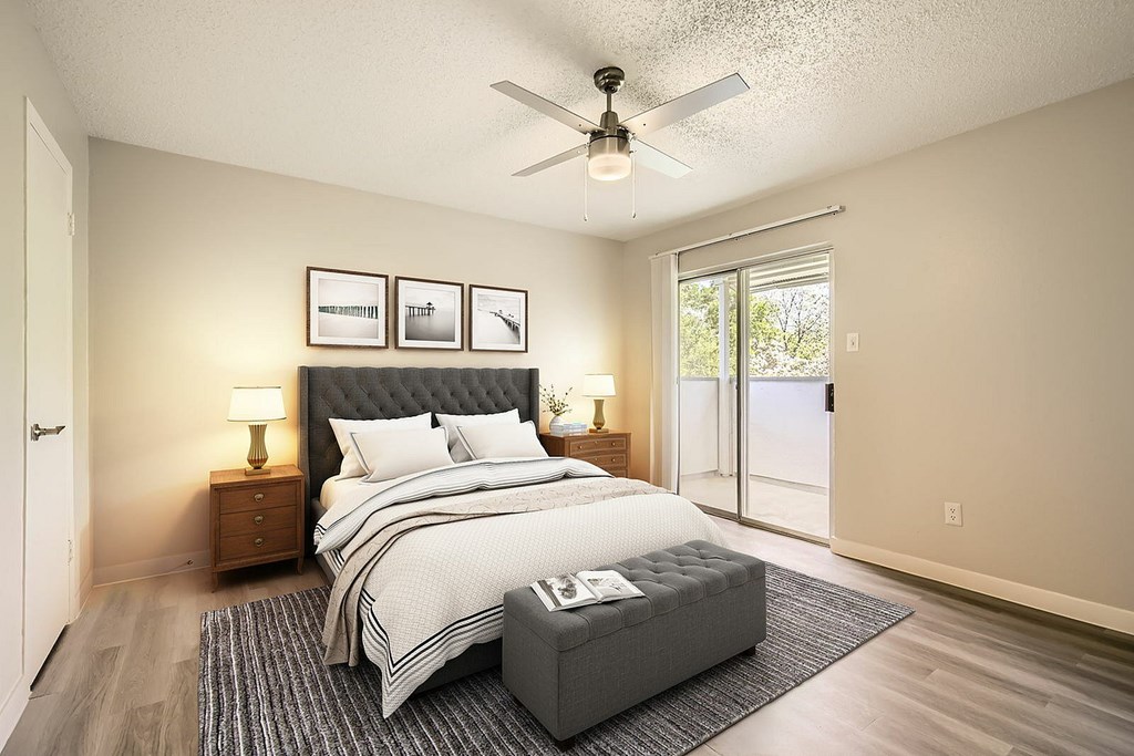 A bedroom with a large bed and a ceiling fan.