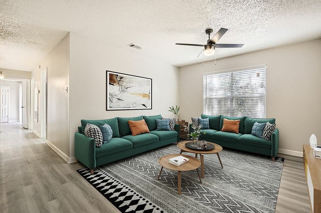 A living room with a green couch and a rug.