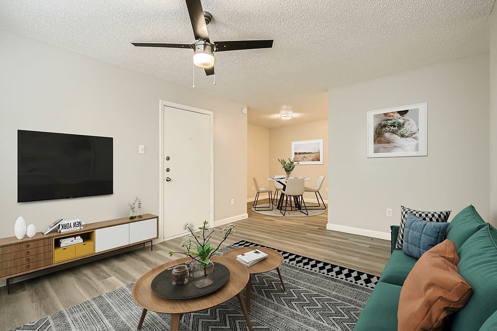 A living room with a brown coffee table and a green couch.