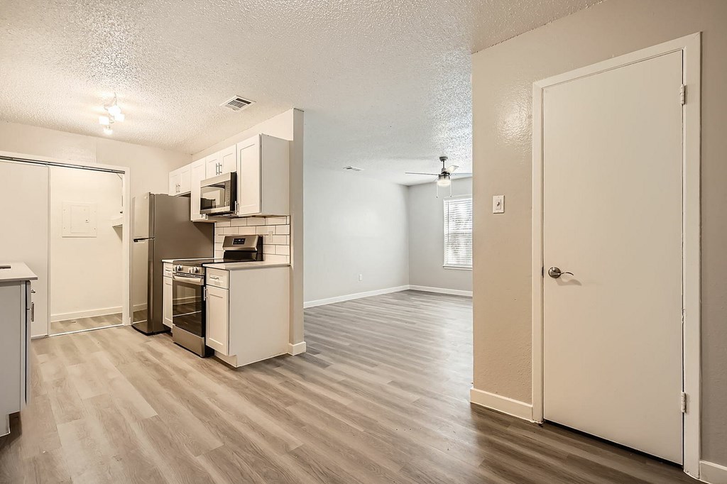 A kitchen with a refrigerator, oven, and microwave.