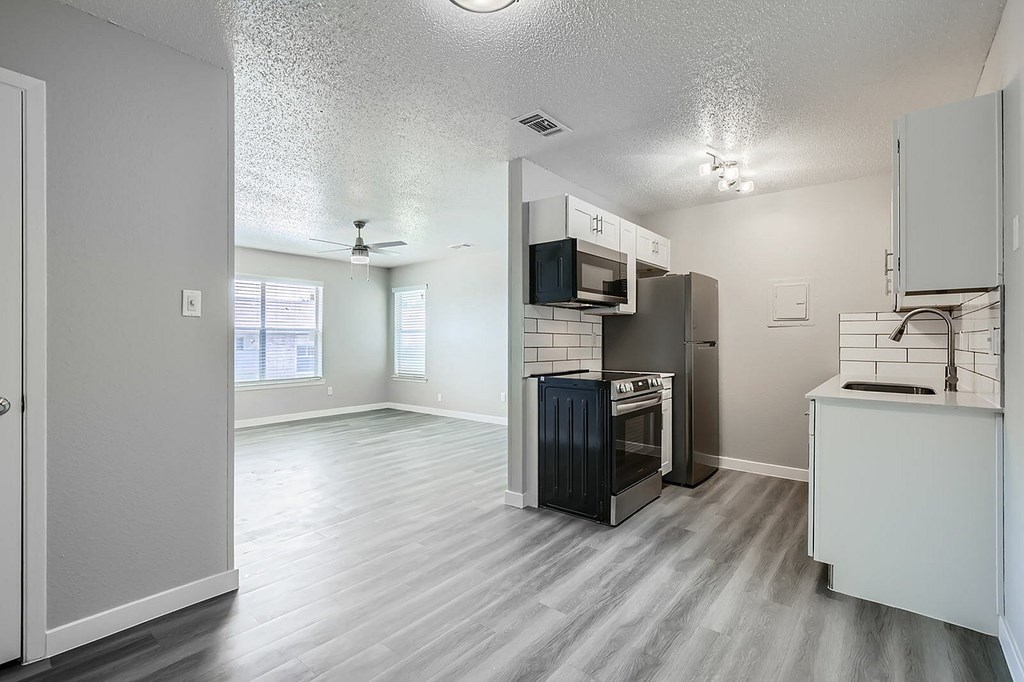 A kitchen with a microwave, oven, and sink.