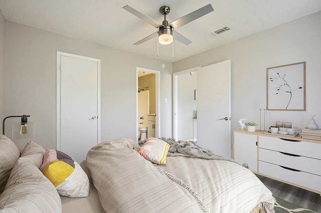 A bedroom with a bed, dresser, and mirror.
