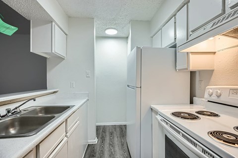 A kitchen with a white stove and a white refrigerator.