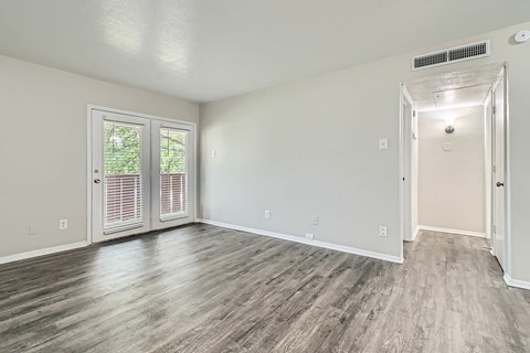 A room with a sliding glass door and a white door.