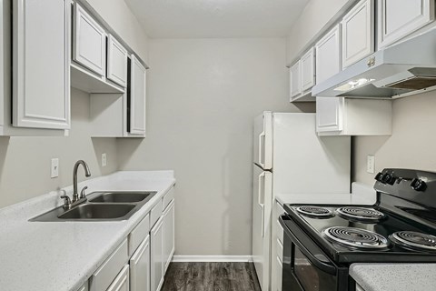 A kitchen with white cabinets and a black stove top oven.