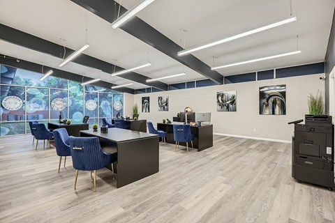 A modern office space with blue chairs and wooden floors.