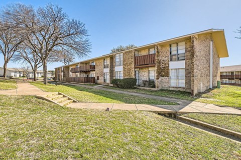 Apartment complex with a grassy area in front.