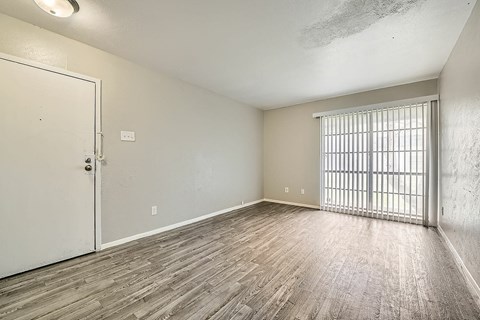 A room with a white door and a window with bars on it.