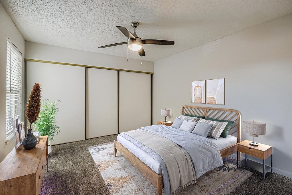 A living room with a flat screen TV, a couch, and a dining area in the background.