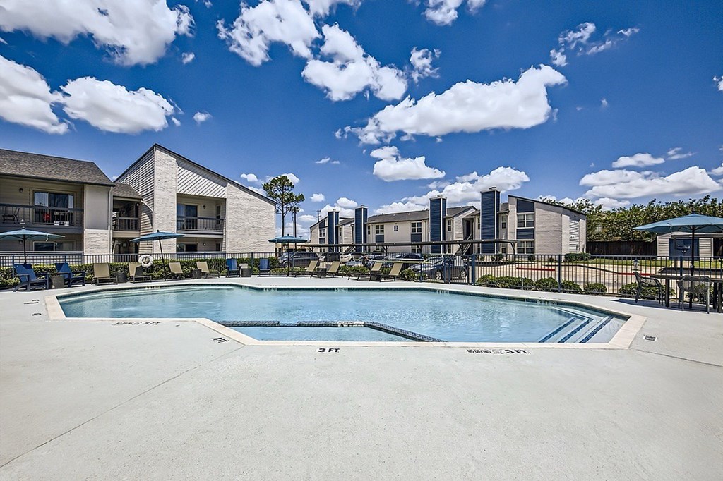 A swimming pool in front of a building complex.
