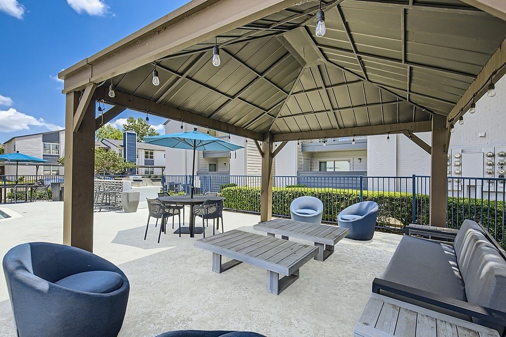 A patio with a table and chairs under a roof.