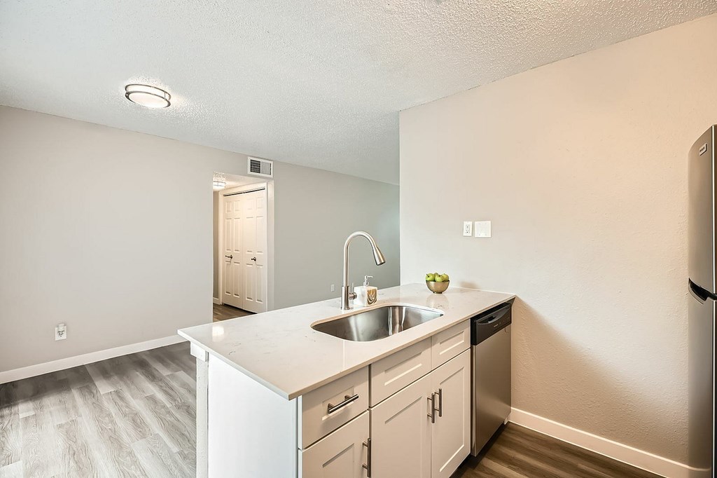 A kitchen with white cabinets and a white sink.