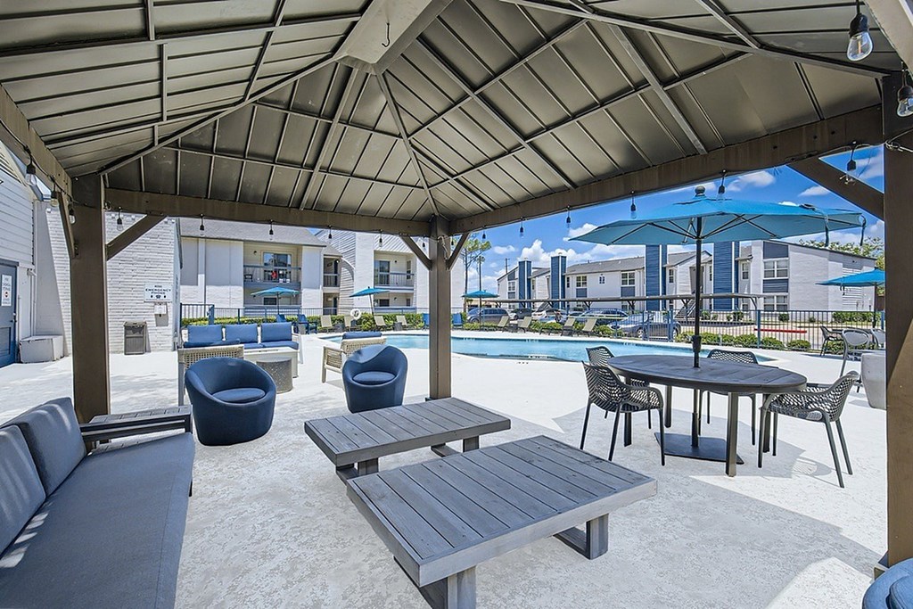 A patio with a table and chairs under a canopy.