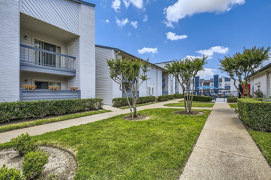A sunny day at a residential area with apartment buildings and greenery.