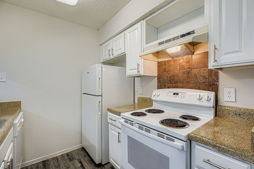 A kitchen with white appliances and cabinets.
