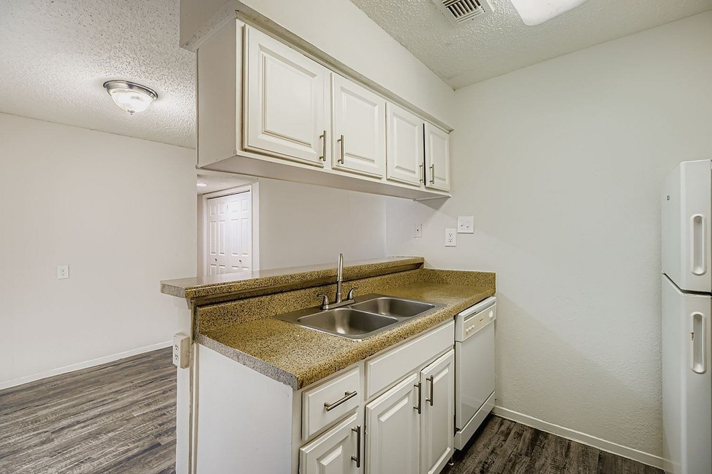 A kitchen with white cabinets and a granite countertop.