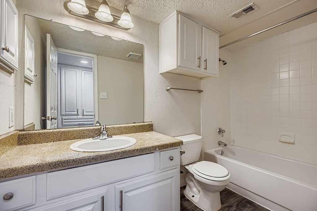 A white bathroom with a sink, toilet, and bathtub.