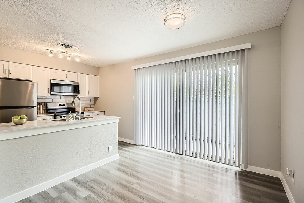 A kitchen with a refrigerator, microwave, and oven.