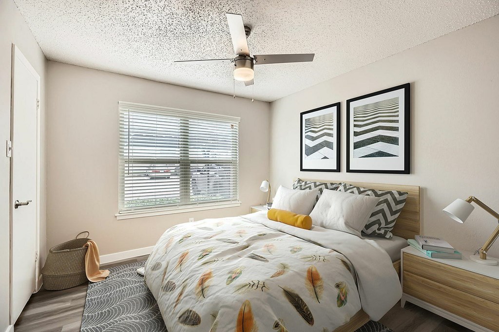 A bedroom with a bed, nightstand, and two framed pictures on the wall.