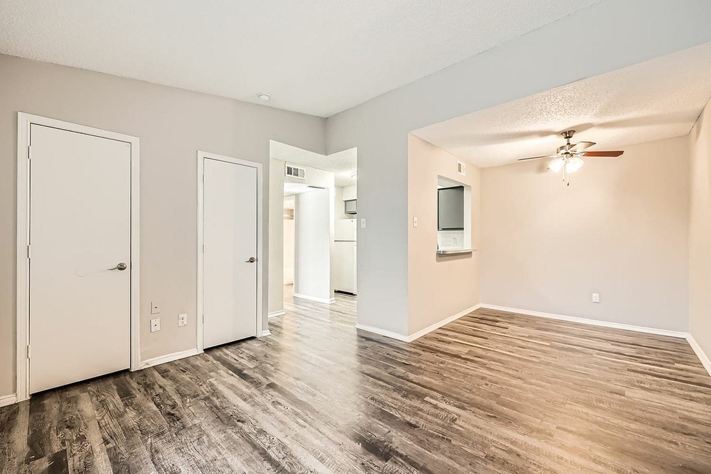 A room with a wooden floor and a ceiling fan.