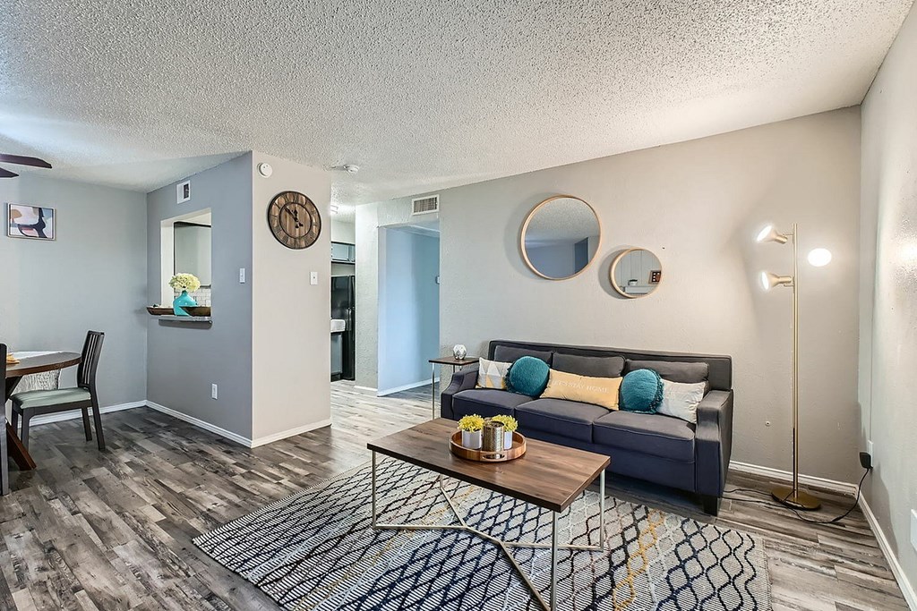A living room with a grey couch and a wooden coffee table.
