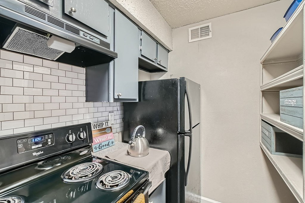 A kitchen with a black stove and a black refrigerator.