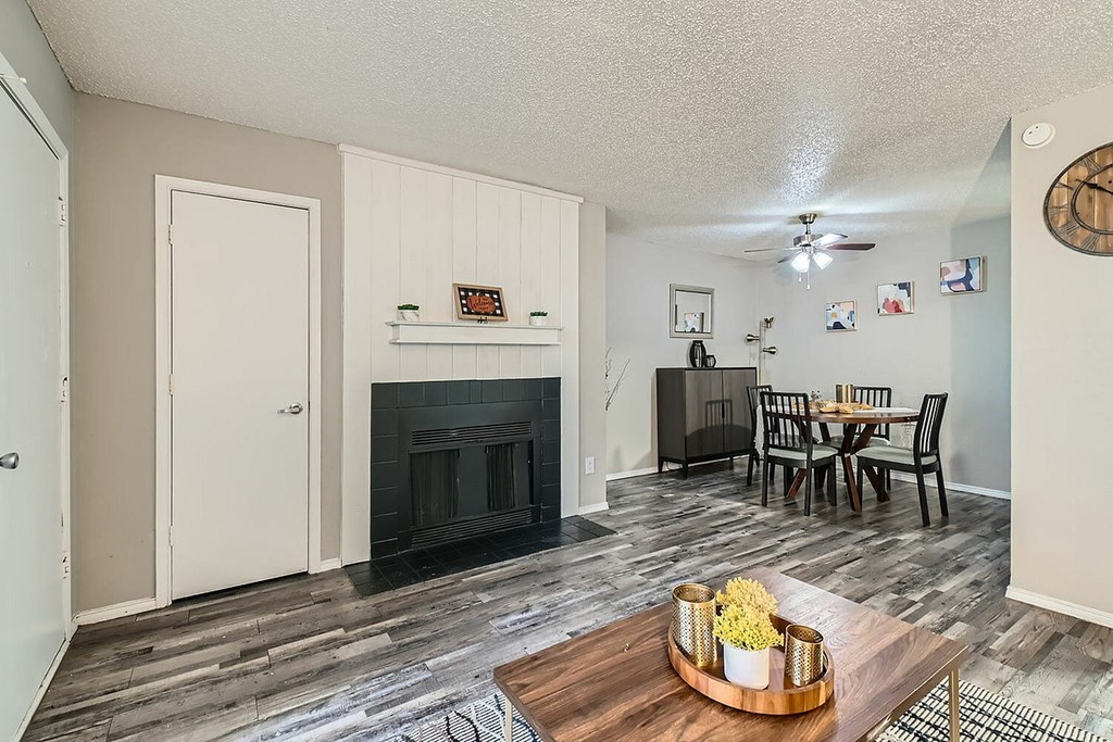 A living room with a fireplace and a dining table.