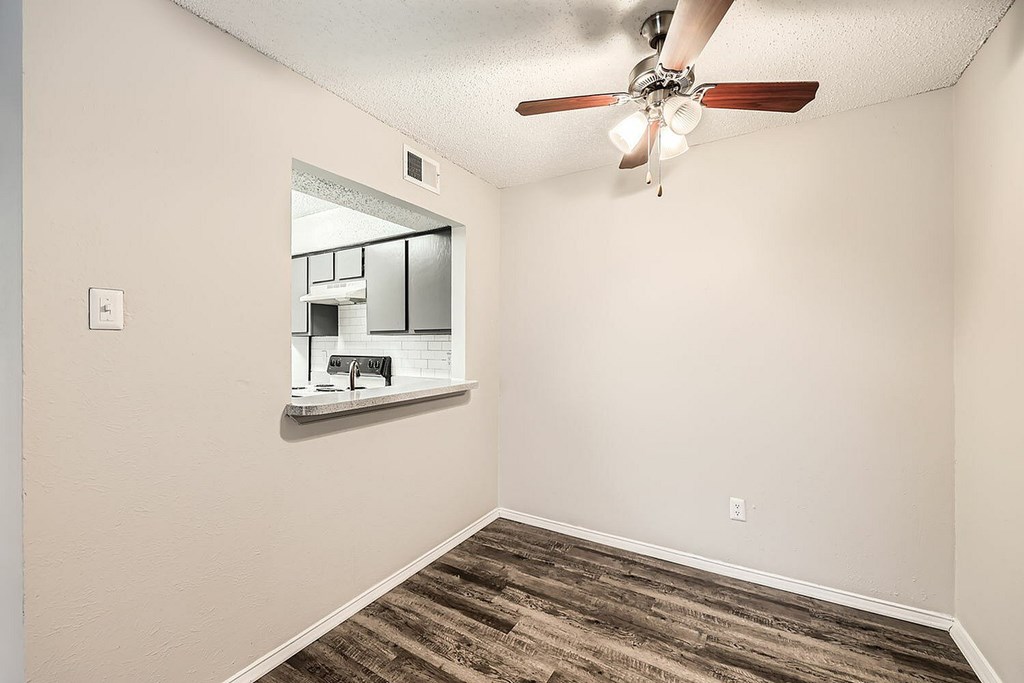 A room with a ceiling fan and a mirror on the wall.