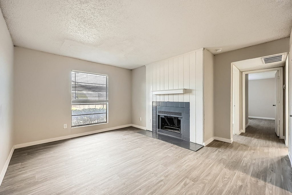 A room with a fireplace and a window with blinds.