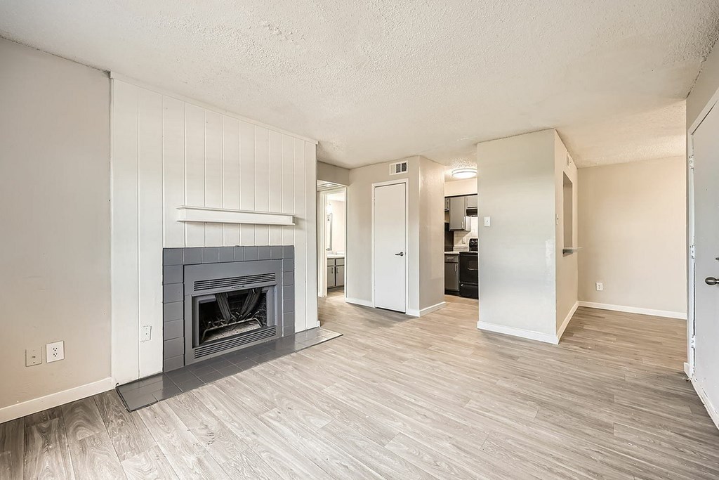A living room with a fireplace and wood flooring.