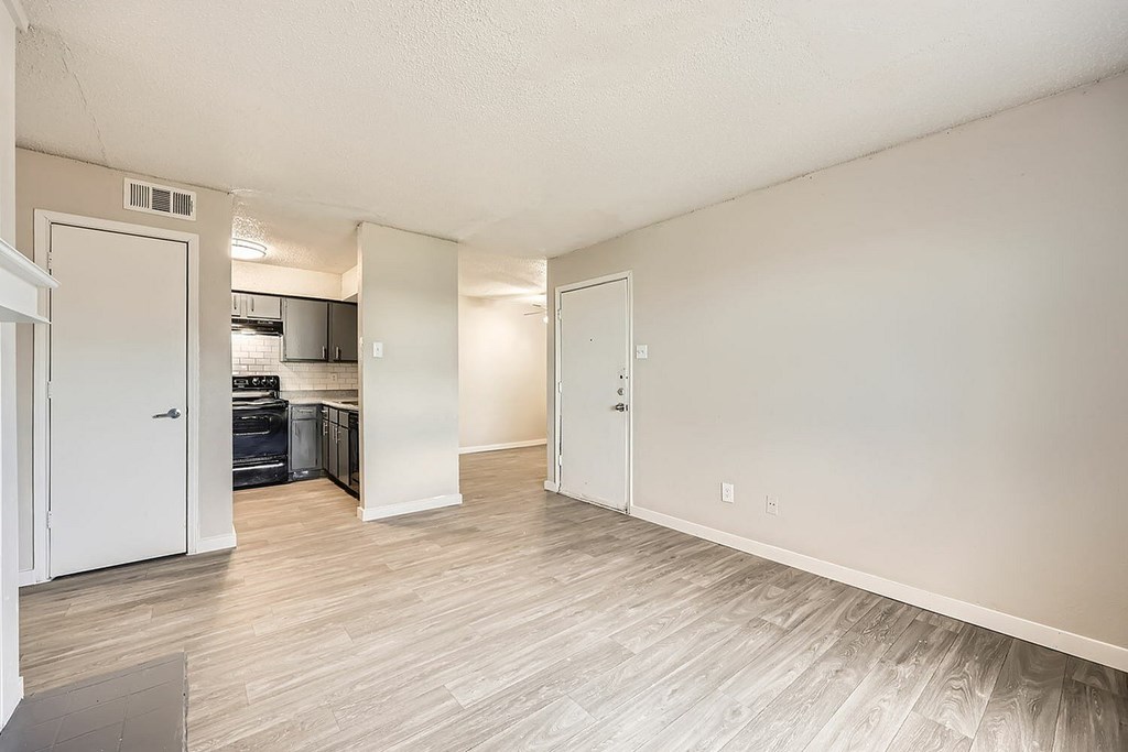 A room with a white door and a grey floor.