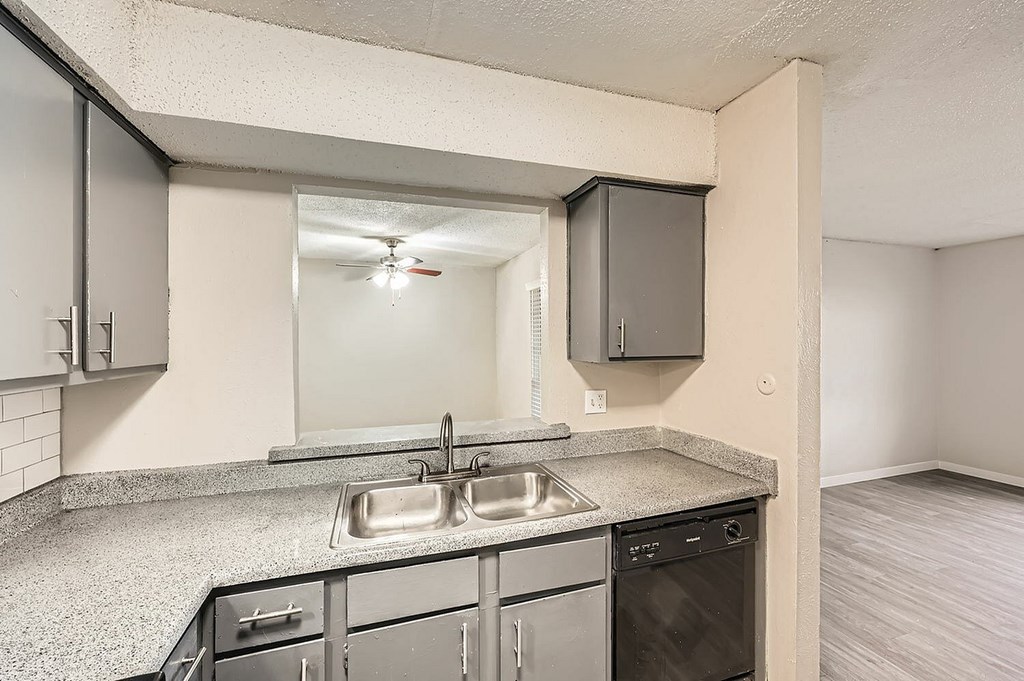 A kitchen with a sink, stove, and oven.