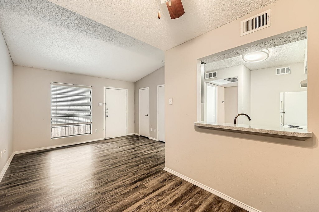A room with wooden floors and a large mirror on the wall.