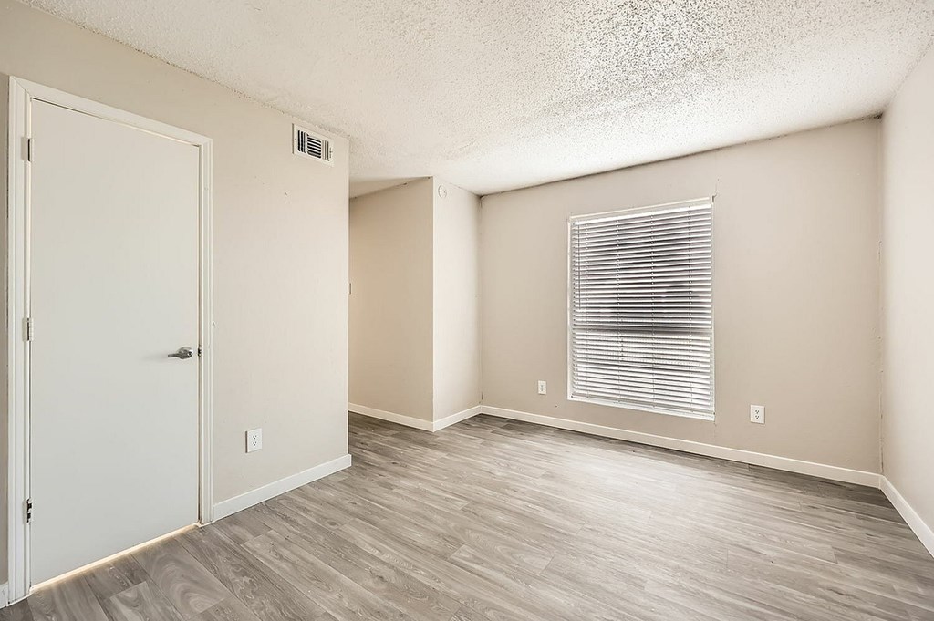 A room with a white door and a window with blinds.