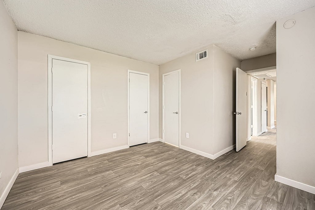 A room with wood flooring and white walls.