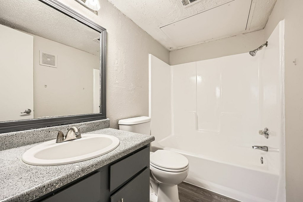 A bathroom with a toilet, sink, and bathtub.