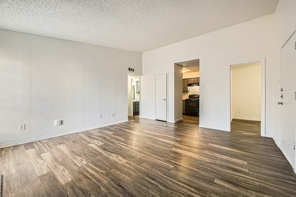 A room with wooden flooring and white walls.
