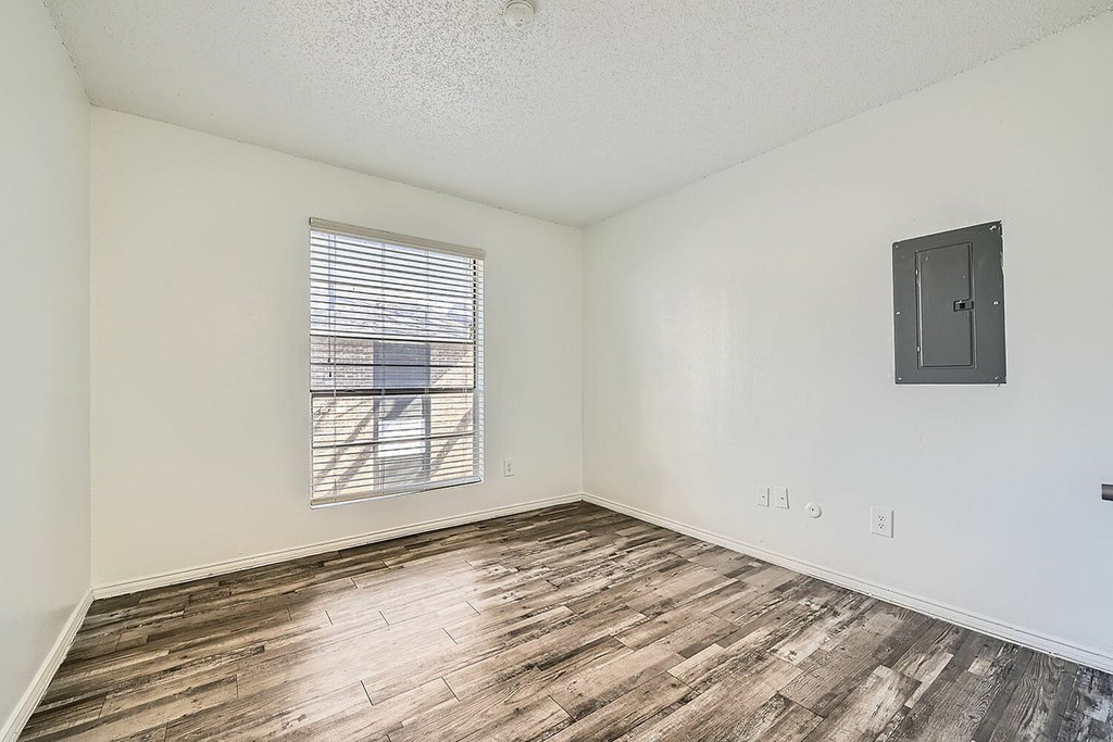A room with a window and wooden flooring.