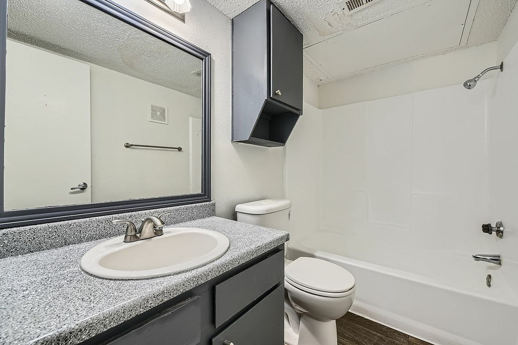A bathroom with a sink, toilet, and bathtub.