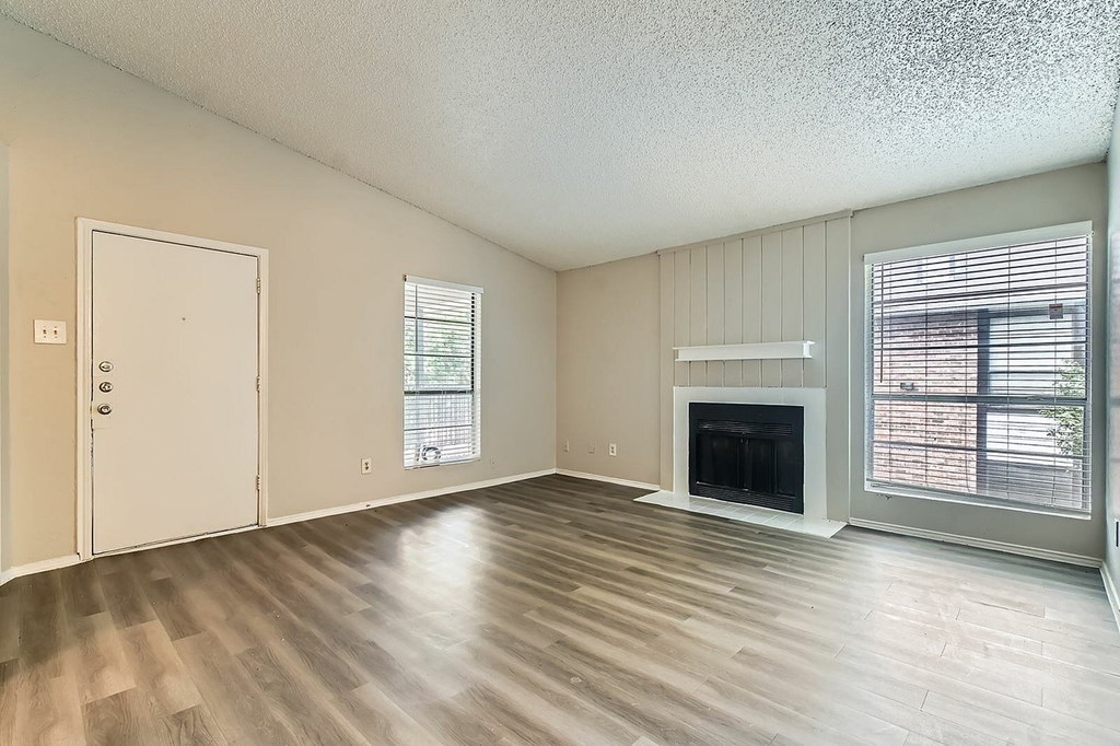 A room with a fireplace and a window with blinds.