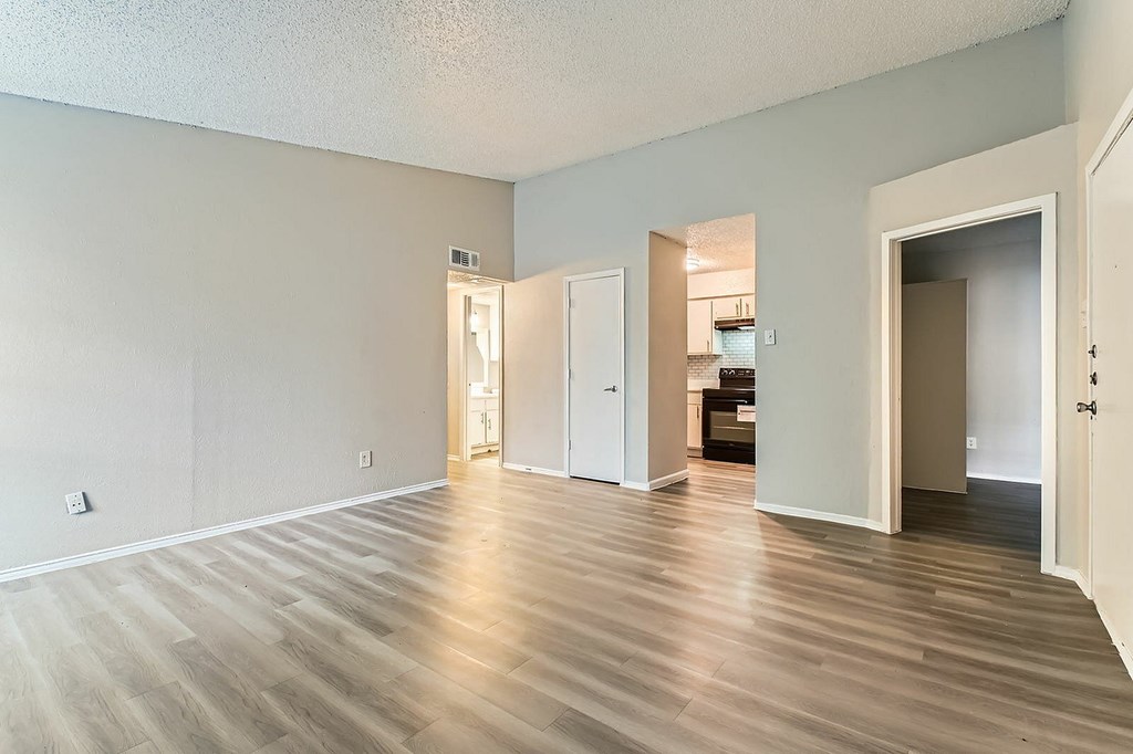 A room with light wood flooring and white walls.