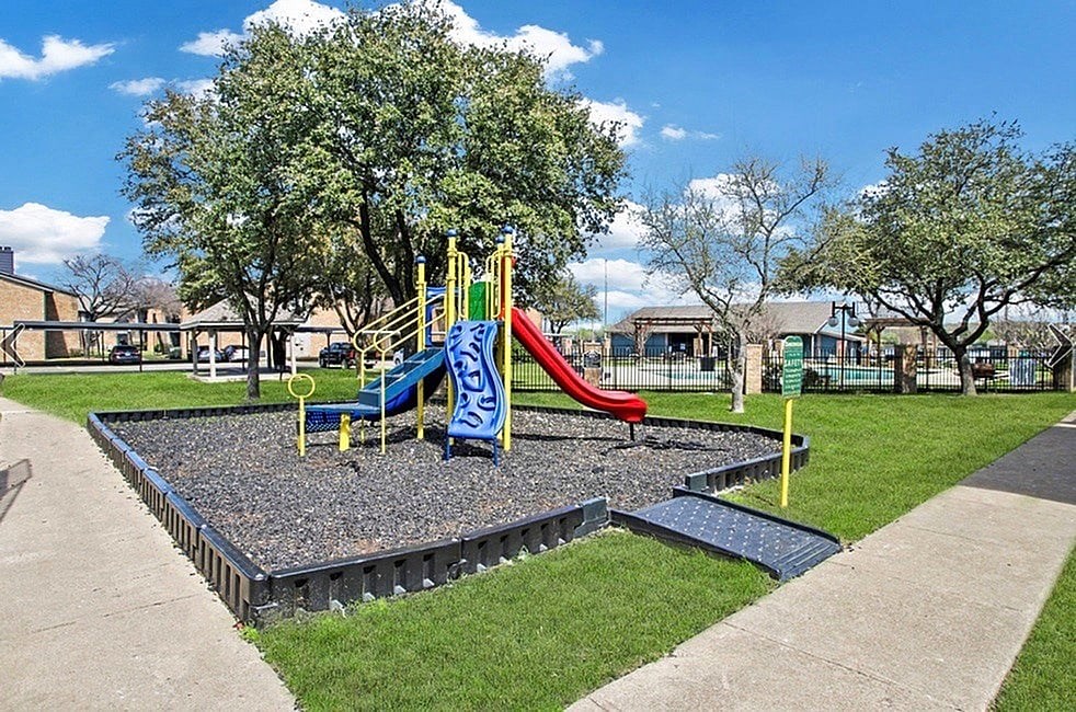 A playground with a blue and yellow slide.