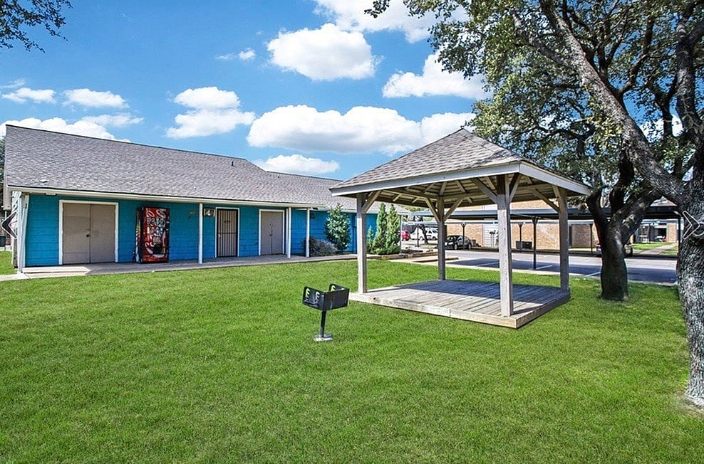 A small building with a blue roof and a gazebo in front of it.