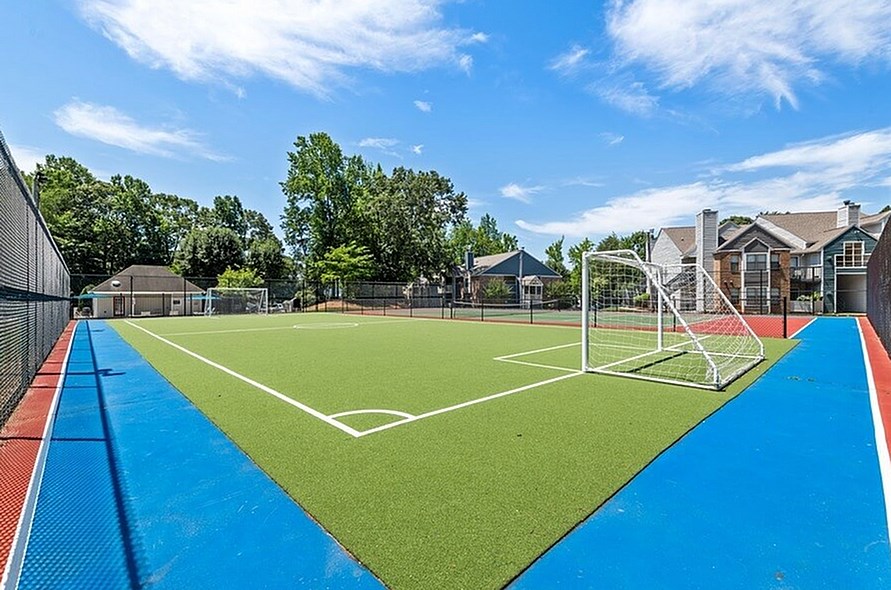 A soccer field with a blue and red surface and white lines.