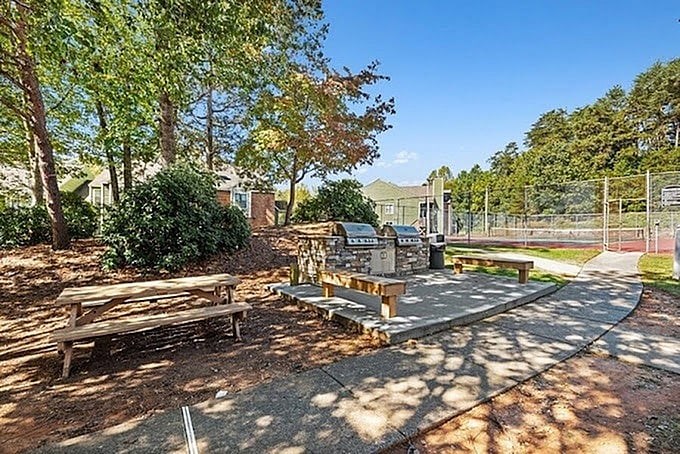 A park with a playground and picnic tables.
