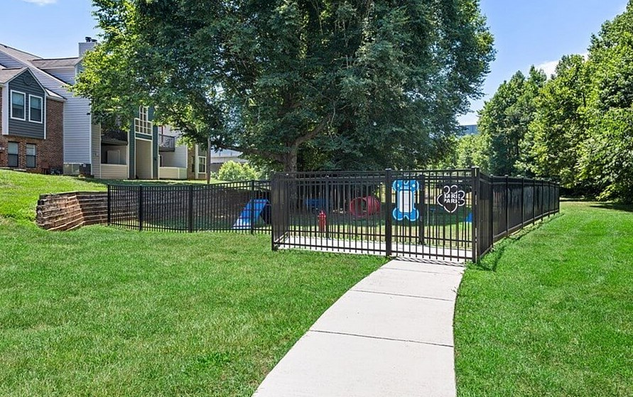 A black fence with a sign that says "No Trespassing" is in front of a house.