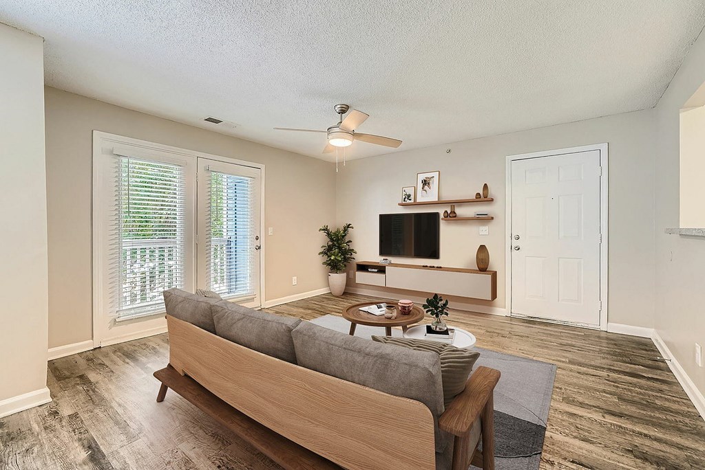 A living room with a couch, a table, and a television.